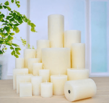 Scented pillar candles collection displayed in various sizes on a wooden table, providing warmth and aesthetic beauty.
