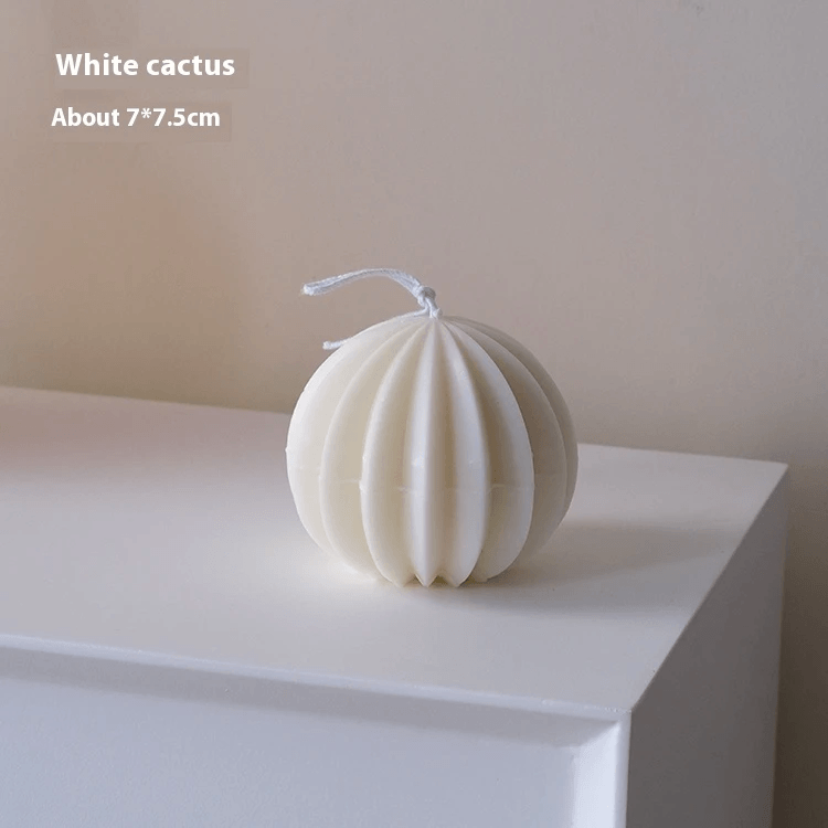 Handmade geometric aromatherapy candles in a white cactus design on a shelf.