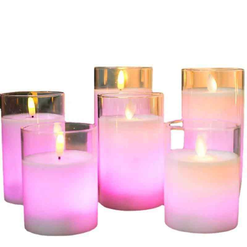 Color changing candles with remote control in various colors illuminating a cozy setting.