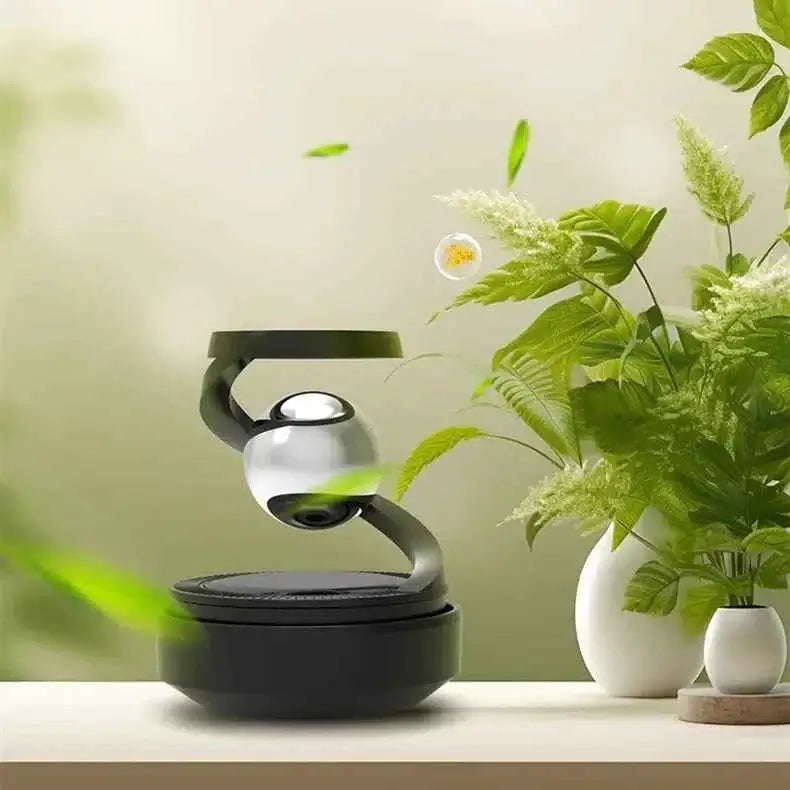 Solar car aromatherapy diffuser on a table surrounded by green plants, showcasing sleek design and eco-friendly features.