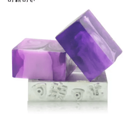 Handmade soap with essential oils in purple hues stacked elegantly.