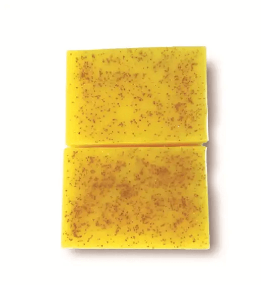 Turmeric citric acid soap in two rectangular bars with a speckled yellow surface.