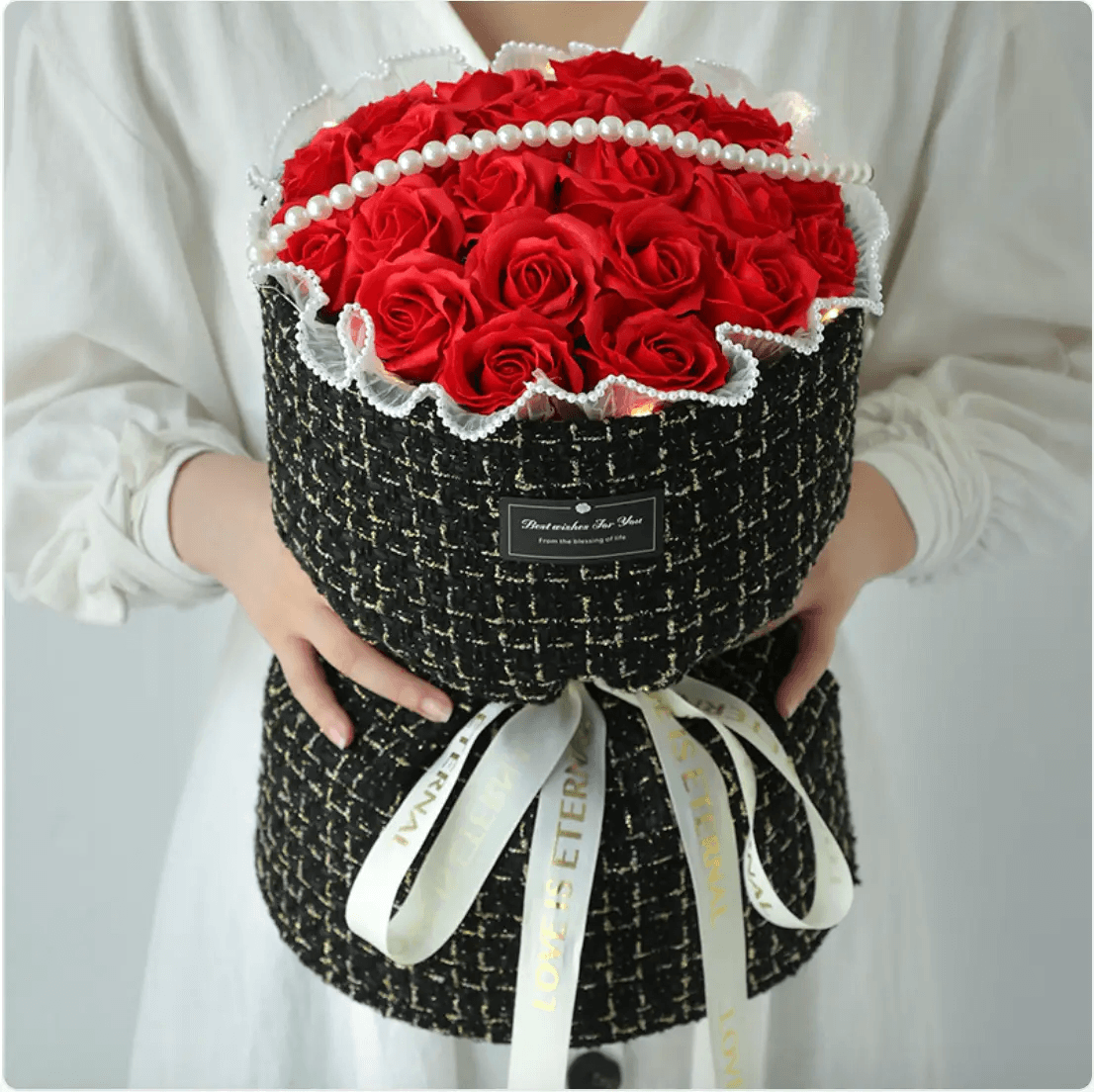 Classic red rose soap bouquet beautifully arranged in a stylish black fabric holder with decorative ribbon.