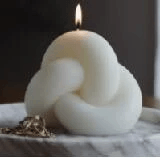 Handmade geometric aromatherapy candles in a sculptural knot design with a warm flame.