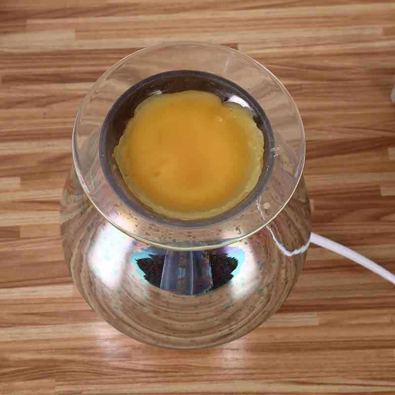 Aromatherapy lamp with candle burner showcasing a yellow wax melt in a sleek glass design.