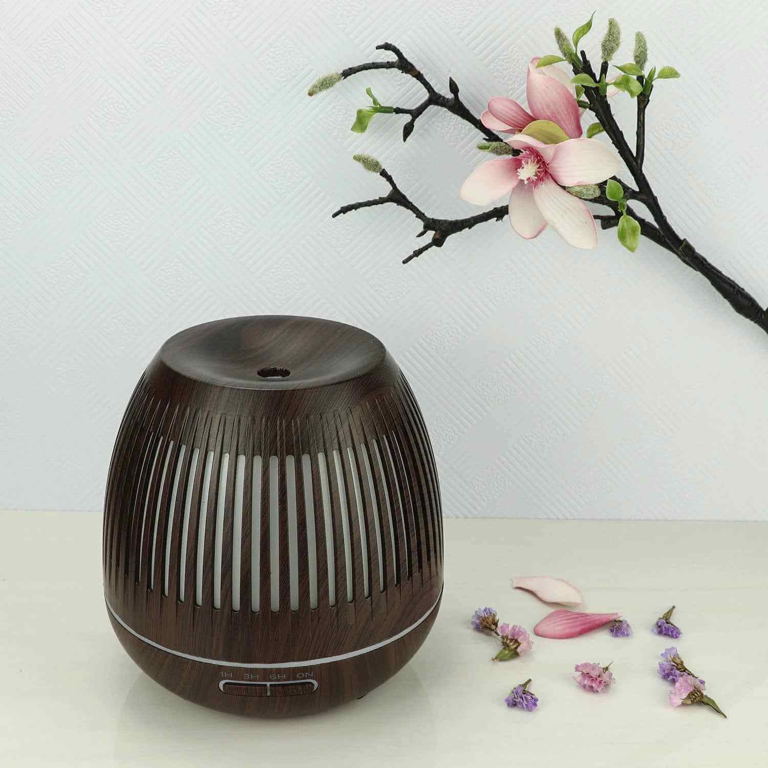 Aromatherapy humidifier with LED lights placed beside a flower, creating a calming atmosphere.