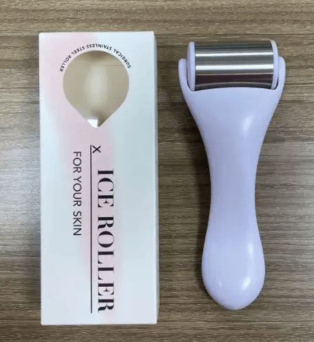 facial massage tool next to packaging on wooden surface, designed for skincare routines and skin rejuvenation.