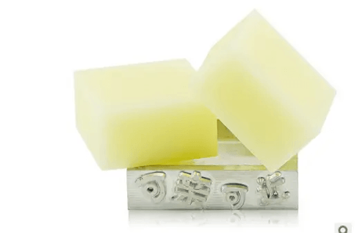 Handmade soap with essential oils on a silver tray showcasing two yellow bars.