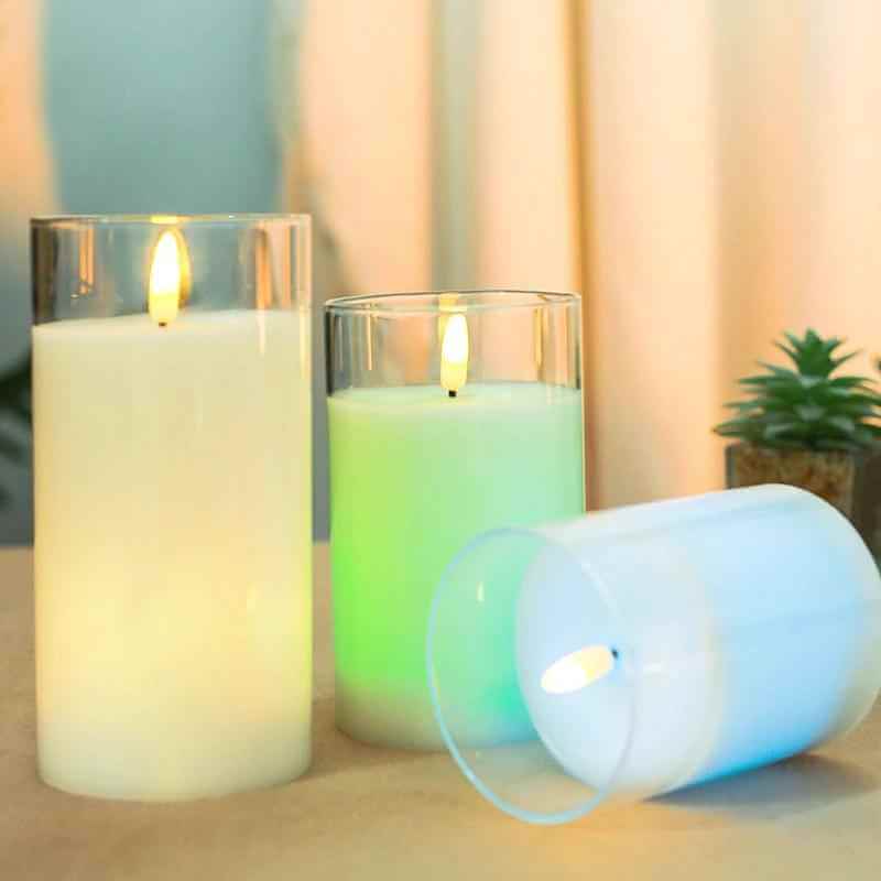 Color changing candles with remote control in glass cup illuminating vibrant colors.