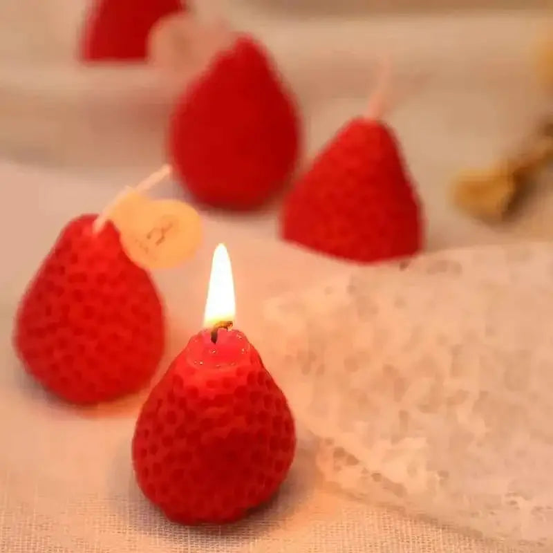 Cute strawberry candles for parties glowing in a festive setting, perfect for celebrations and decorations.