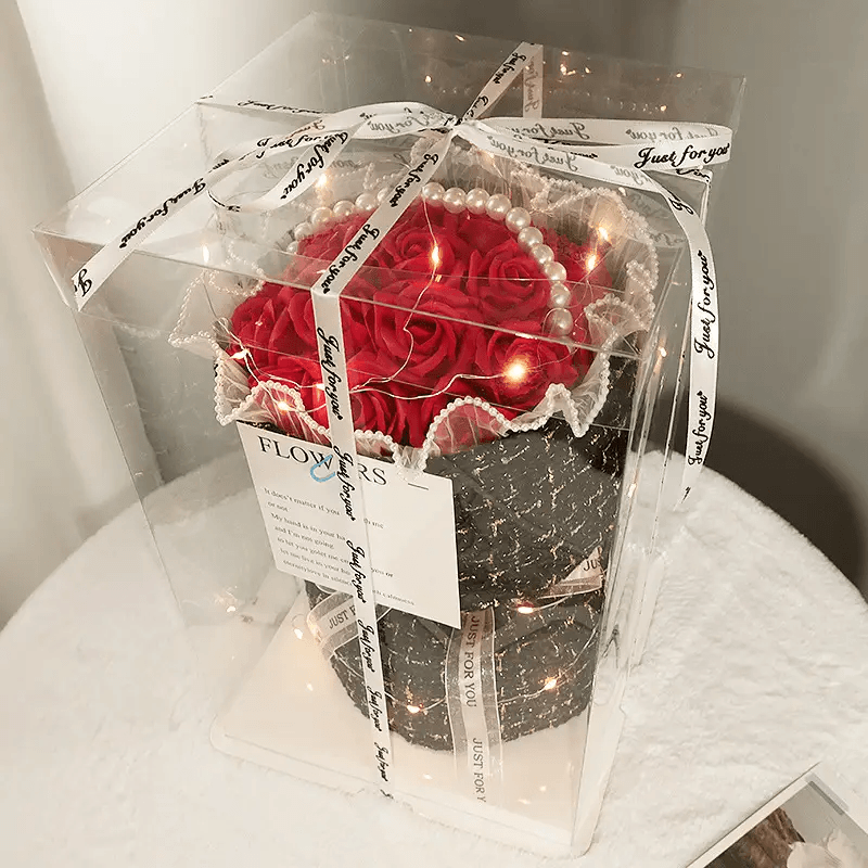 Elegant soap flower bouquet featuring red roses, adorned with pearls and lights, elegantly packaged in a display box.