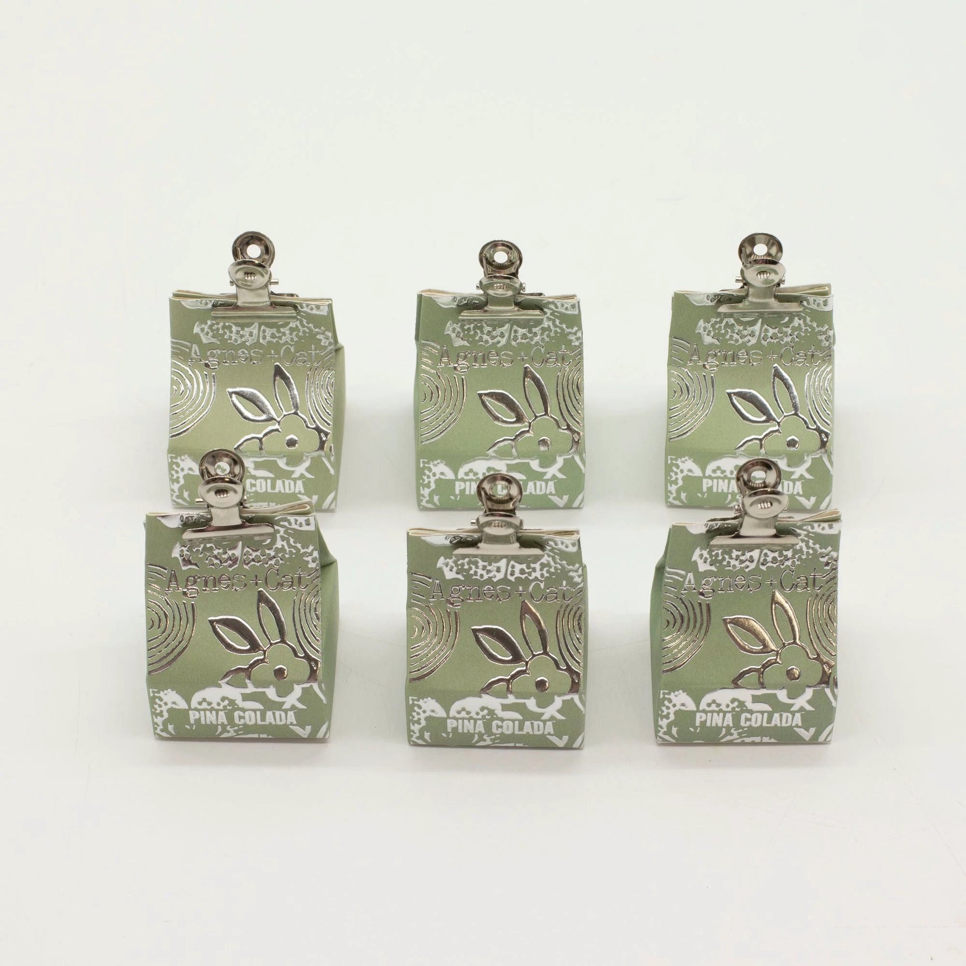 Agnes + Cat Pinacolada lip balm packaging displayed in six units on a white background, showcasing the coconut scent.