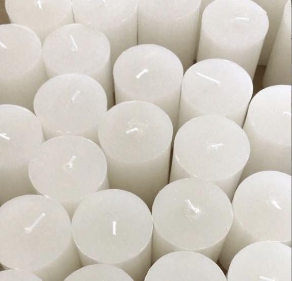 Scented pillar candles collection featuring white cylindrical candles arranged in a visually appealing pattern.