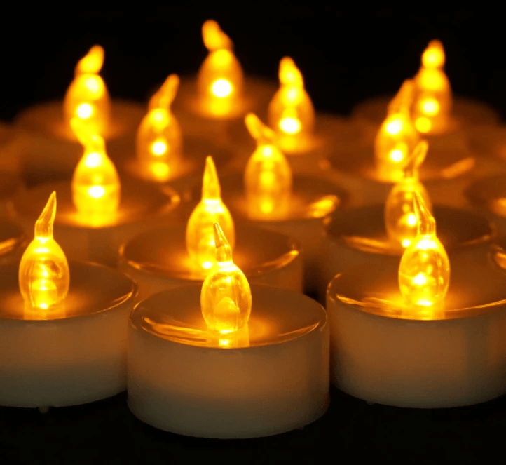 Electronic tea light candles glowing warmly in a festive arrangement for Christmas decor.