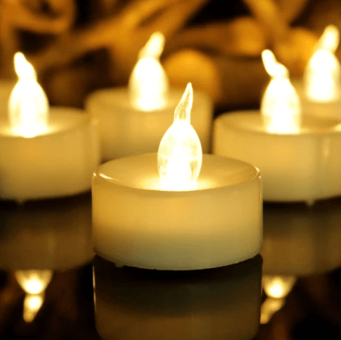 A close-up of electronic tea light candles with soft glowing LED flames, perfect for festive decor.