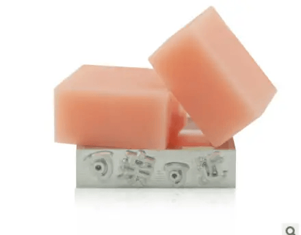Handmade soap with essential oils featuring elegant pink bars arranged attractively on a decorative base.