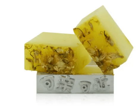 Handmade soap with essential oils featuring floral infusion and a vibrant yellow color.