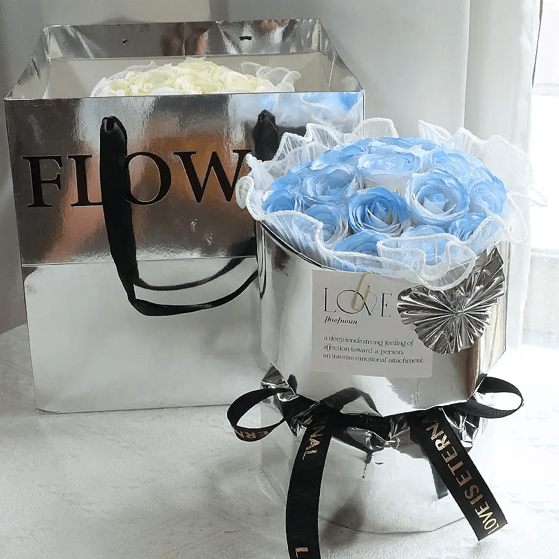 Elegant soap flower bouquet in stylish packaging, showcasing beautiful blue roses and a silver container.